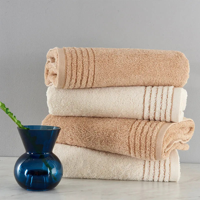Beige and brown cotton towel set showing bath, hand, and face towel sizes.