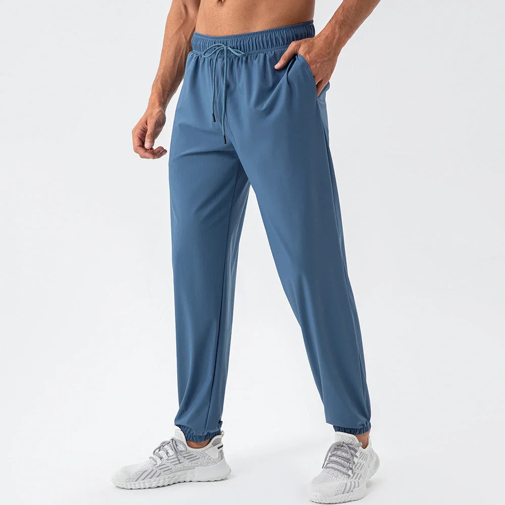 Men's lightweight nylon track pants in various colors, featuring a relaxed, flexible fit for active lifestyles
