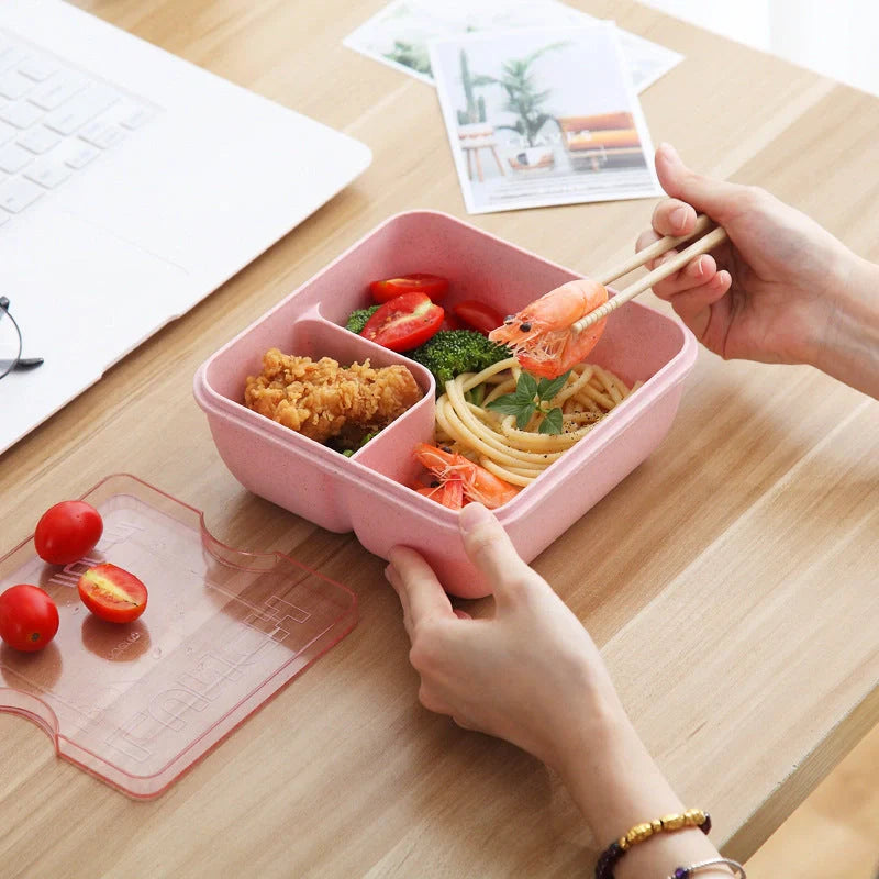 Japanese-style microwave-separated bento box in pink, green, and beige with spoon and chopsticks