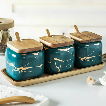 Three-piece Nordic Gold Marble Jar Set in white ceramic with wooden tray and bamboo spoons on kitchen counter