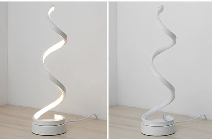 Modern table lamp with curved design, metal base, and acrylic shade offering remote-controlled dimming between warm and white light