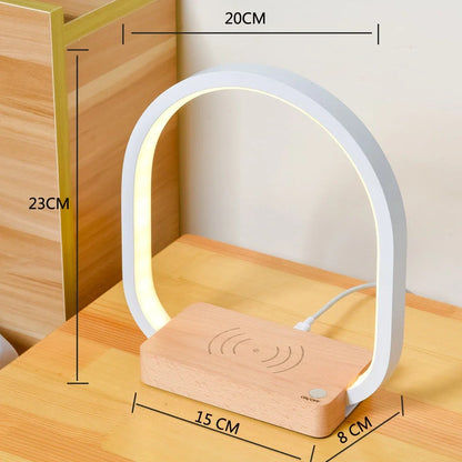 White wireless charging table lamp with metal shade and button switch on wooden surface