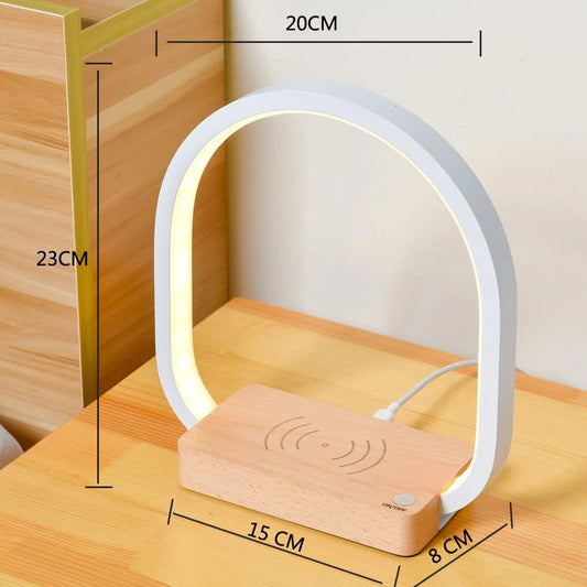 White wireless charging table lamp with metal shade and button switch on wooden surface