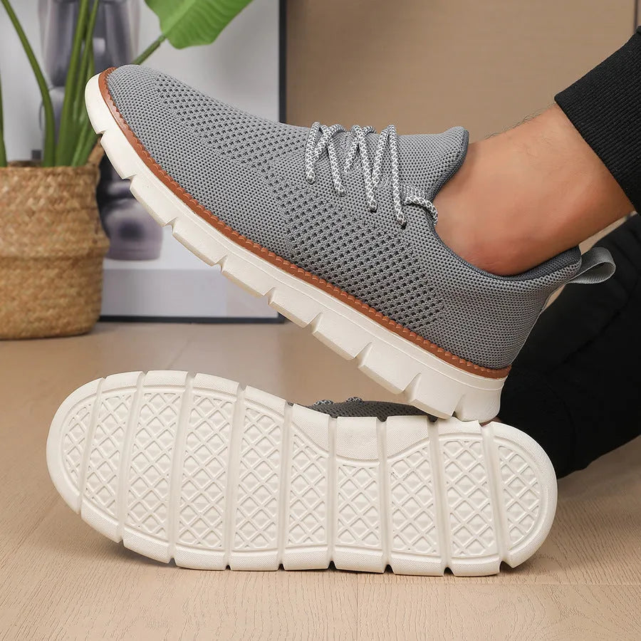 Men's grey and black low-top casual sneakers with a breathable mesh fabric upper.