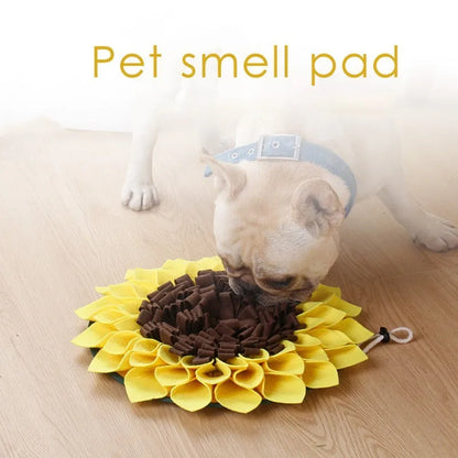 Yellow sunflower-shaped dog snuffle mat for slow feeding and nosework training on a floor.