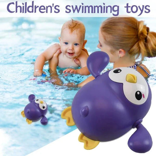 Colorful wind-up penguin bath toy swimming in the water, providing engaging water play for toddlers and young children.