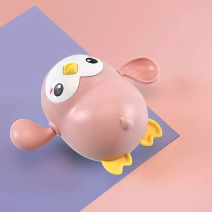 Colorful wind-up penguin bath toy swimming in the water, providing engaging water play for toddlers and young children.