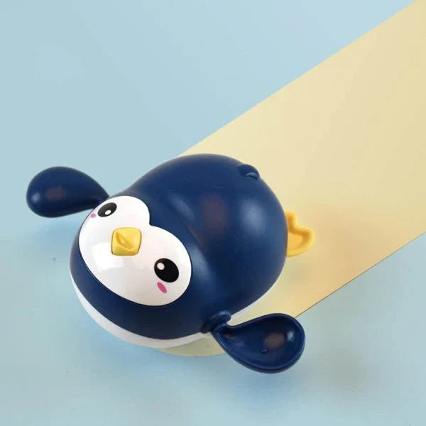 Colorful wind-up penguin bath toy swimming in the water, providing engaging water play for toddlers and young children.