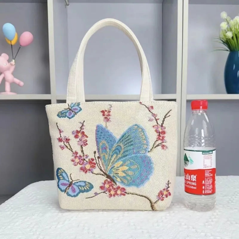Colourful embroidered canvas shoulder bag with gold wire handles shown in small, medium, and large sizes.