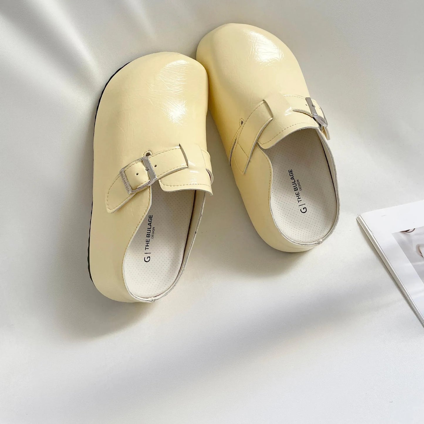 Flat buckle casual sneakers in beige, black, silver, and yellow colours, showing round toe and PU upper.