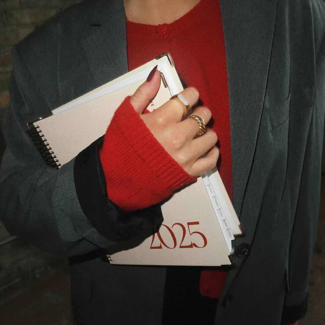 Cherry Red coloured A5 daily schedule coil notebook lying open on a surface.