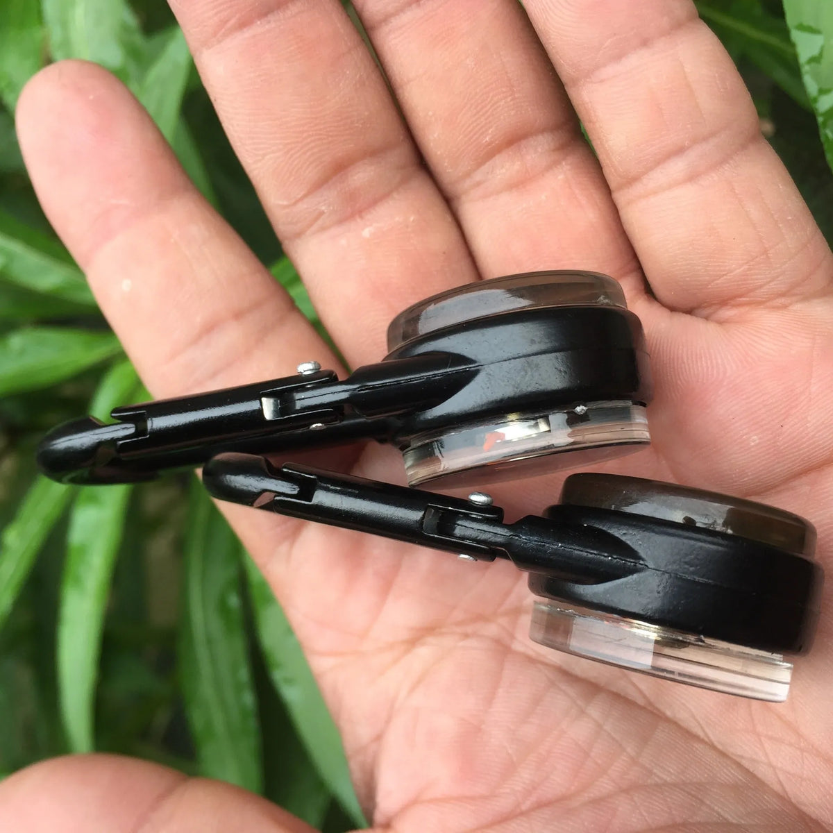 Black outdoor carabiner with a built-in circular compass and thermometer display on its side.