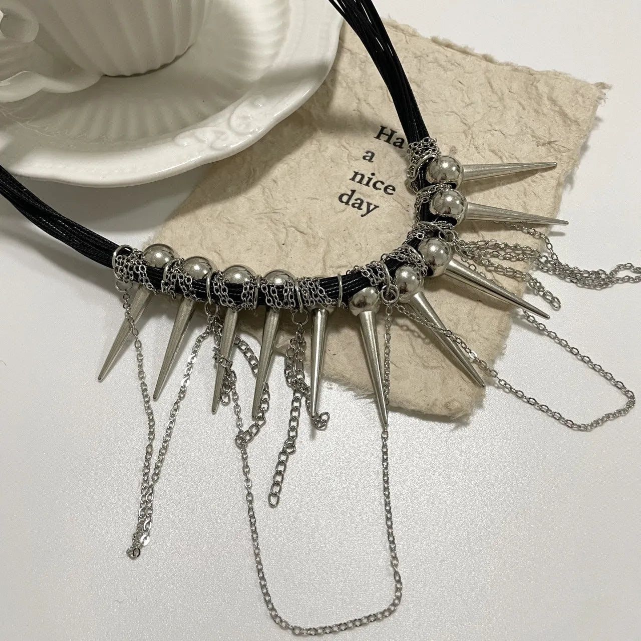 Women's leather necklace with electroplated rivet accents and round beads in winding tassel design