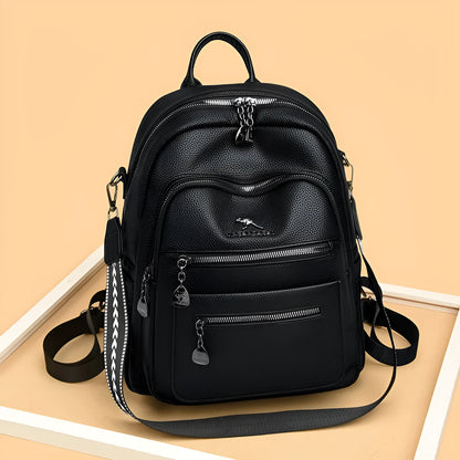 Genuine leather multi-functional commuting backpack with flap pocket, polyester lining, and metal letter patchwork details in black.