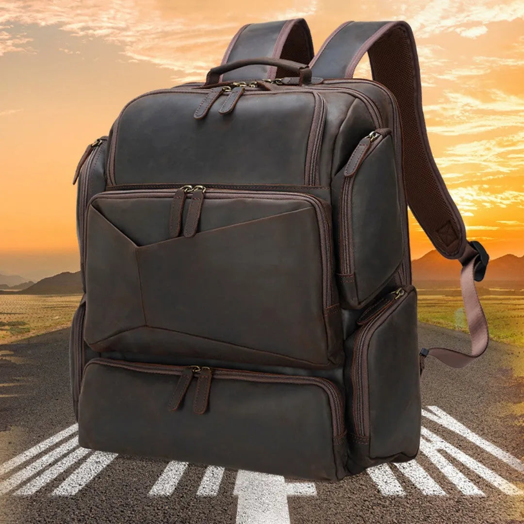 Dark brown leather backpack with embossed texture, double shoulder straps, and multiple zippered compartments for 17-inch laptops
