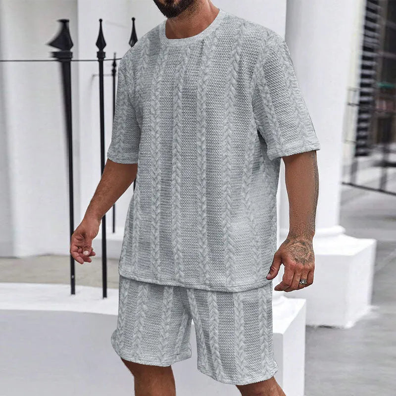Knitted short-sleeve pullover and matching shorts set in light grey, laid flat.