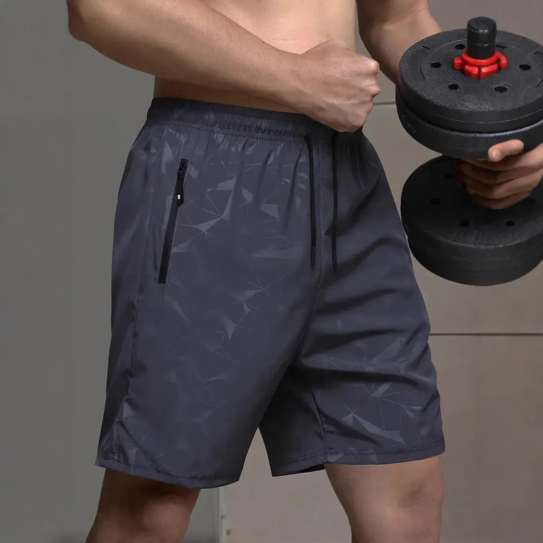 Men's loose-fit casual sports shorts in grey with a printed pattern, showing elastic waistband and fifth-pants length.