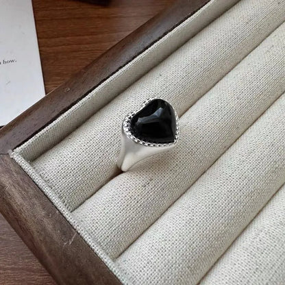 S925 sterling silver ring with a polished black heart-shaped agate stone on an adjustable open band.