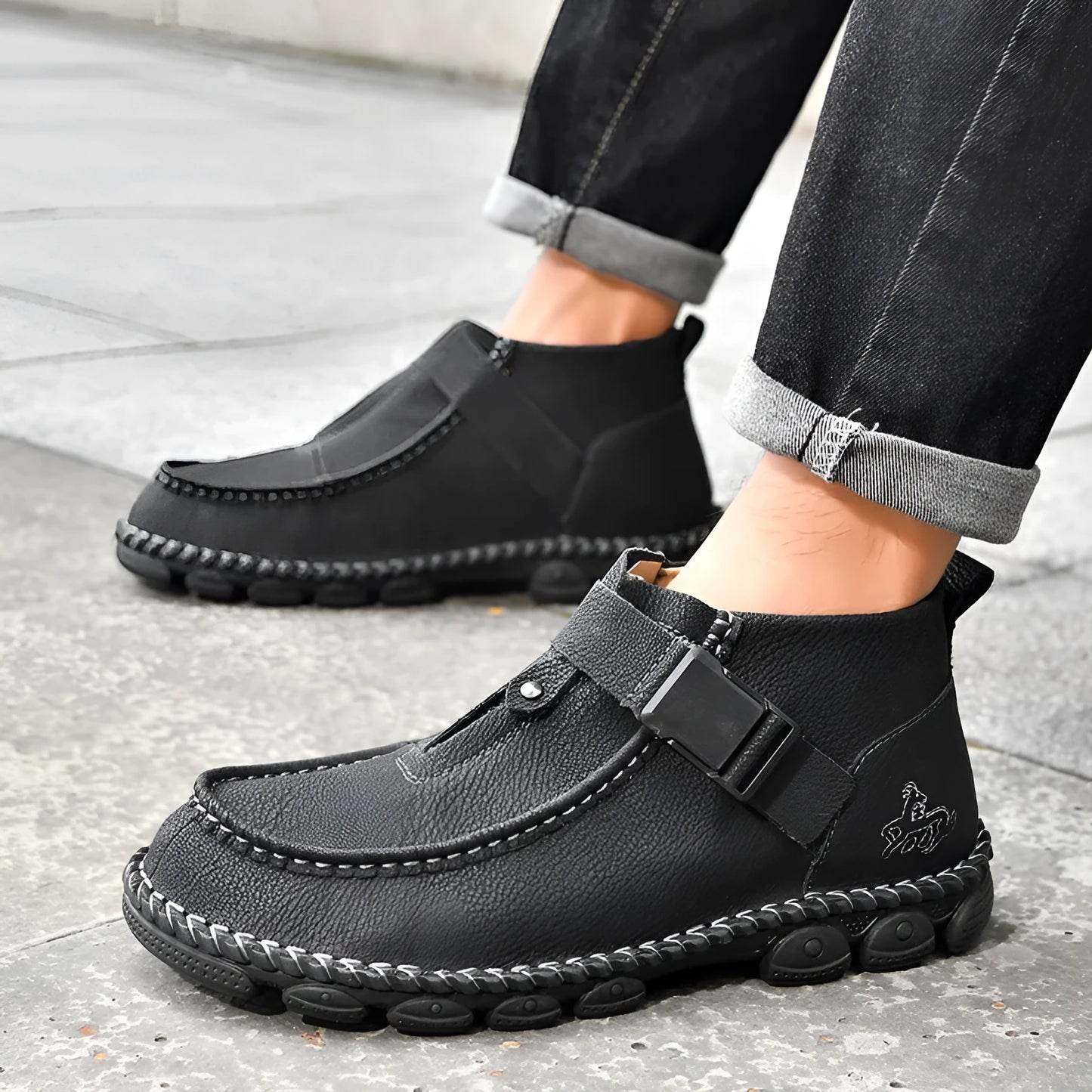 Casual flat bottom slip on shoes in brown with visible handmade sole stitching on a wooden floor.