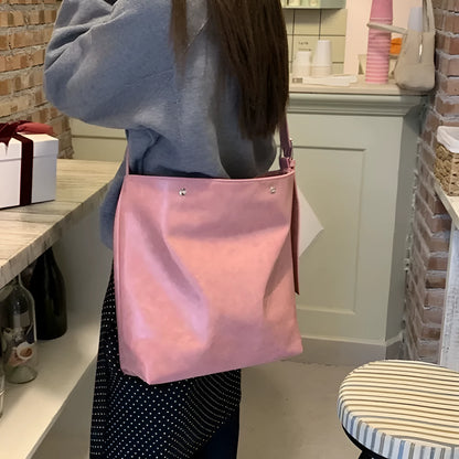 Pink corduroy one-shoulder bag showing its textured fabric and single strap.