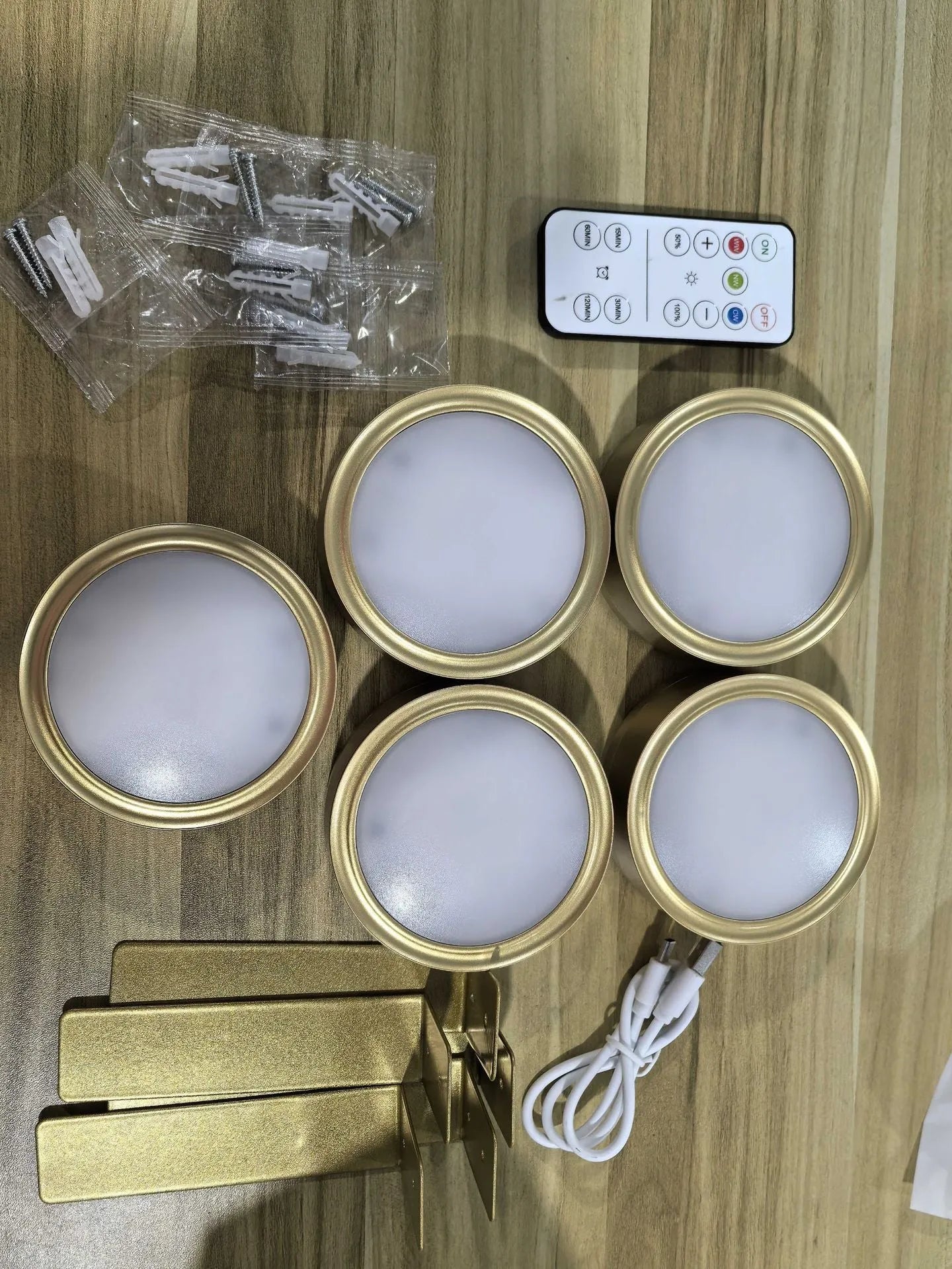 Black magnetic LED painting lamp with remote control on a white wall.