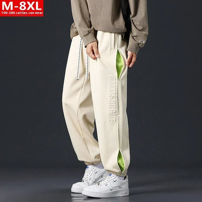 Men's ankle banded trousers in micro-elastic cotton with collage stitching details, showing loose fit and tapered leg