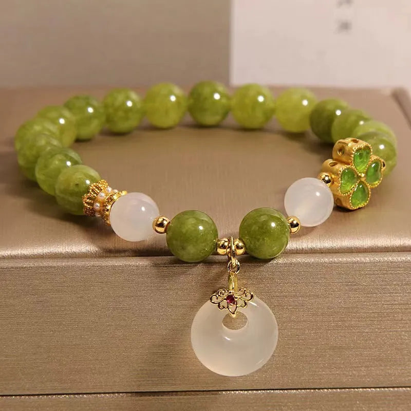 Green tourmaline women's bracelet with four-leaf clover safety buckle and geometric drop shape.