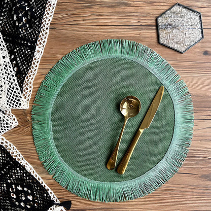 Round handwoven jute placemat with decorative tassels measuring 30cm diameter in Christmas green colour