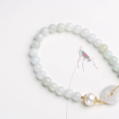 A geometric jade and pearl bracelet for women with a hand-finished peace buckle pendant.