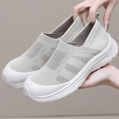 Women's one pedal slip-on shoe in black with cloth upper and PVC sole, showing round toe and flat heel design.