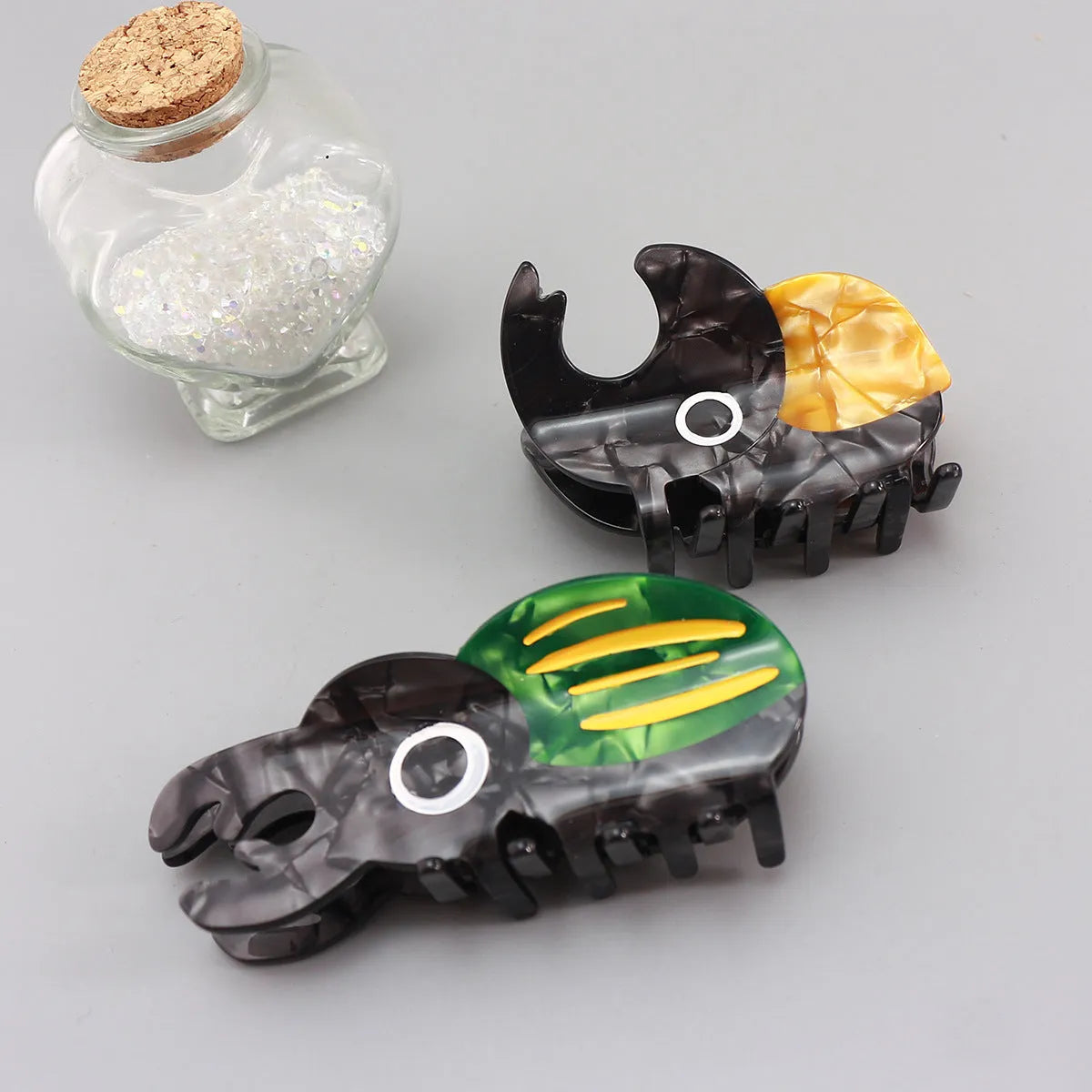 Handmade cartoon insect beetle grip hair clip or brooch in green, orange, or white designs.