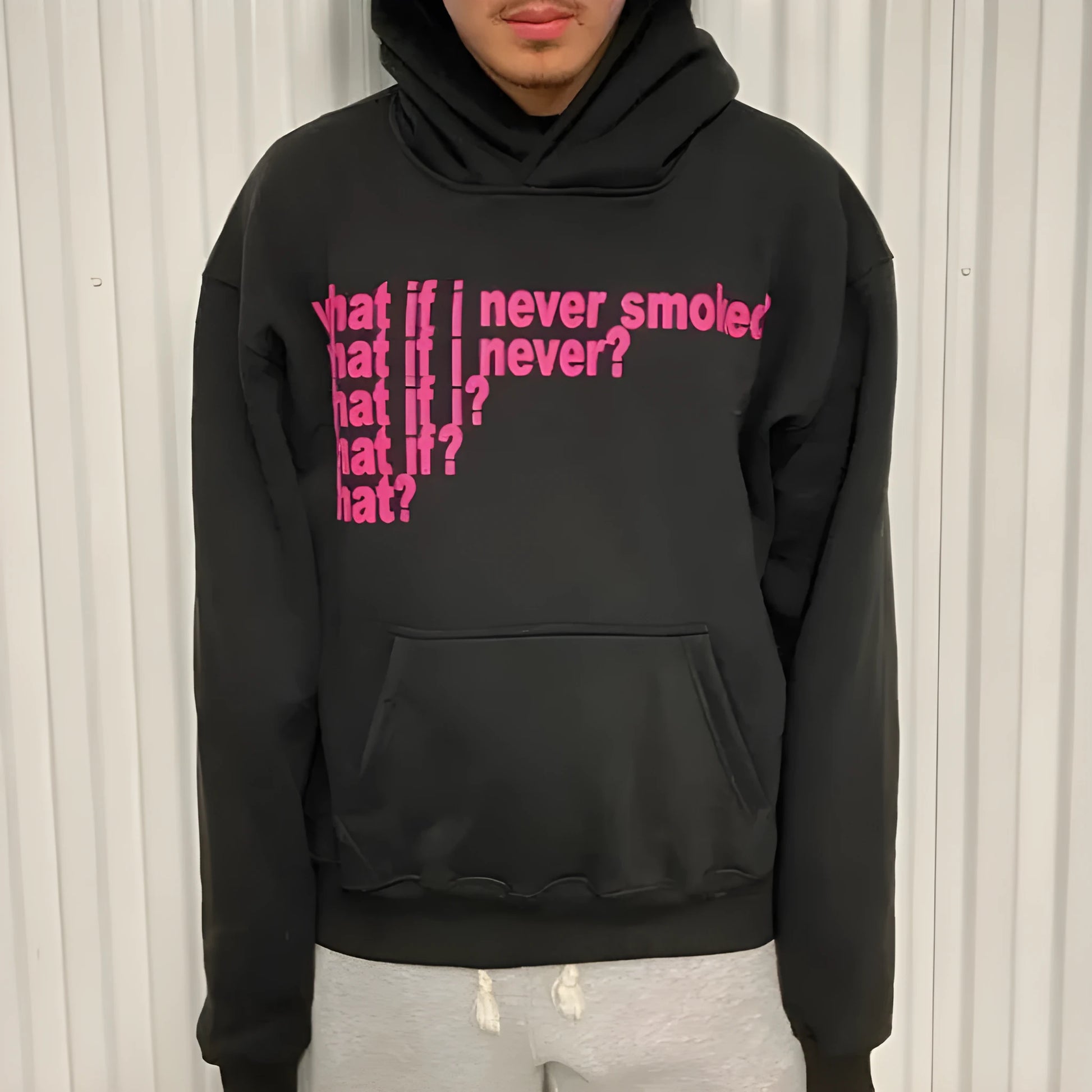 Black hooded pullover sweater with a large letter print on the front, shown on a model.