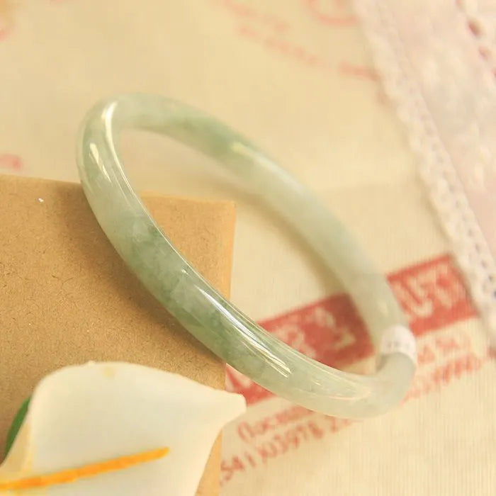 Green geometric jade waxy bracelet on a wrist, showing its 10mm thickness and Chinese style.