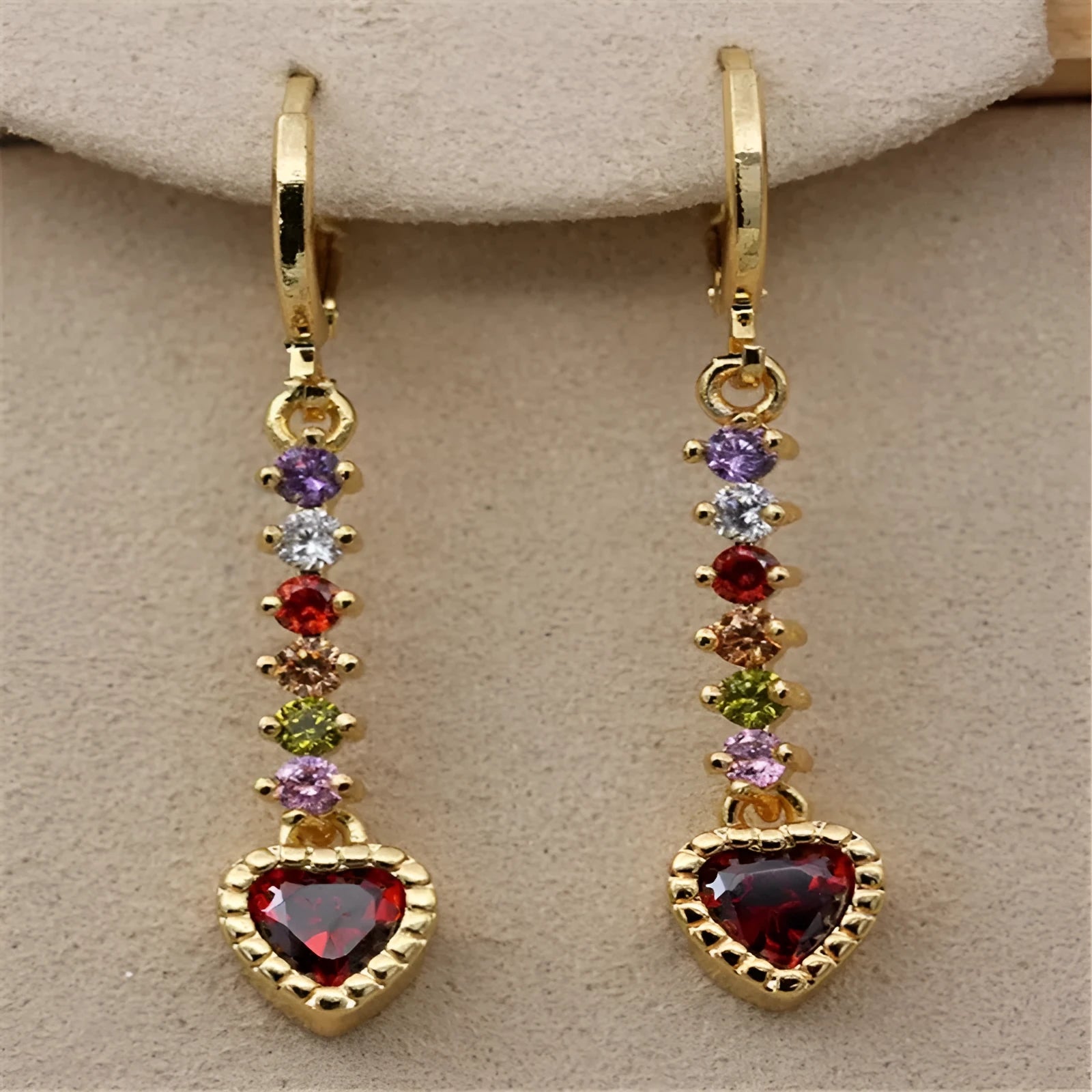 Women's gold and silver heart-shaped alloy drop earrings on a plain background.