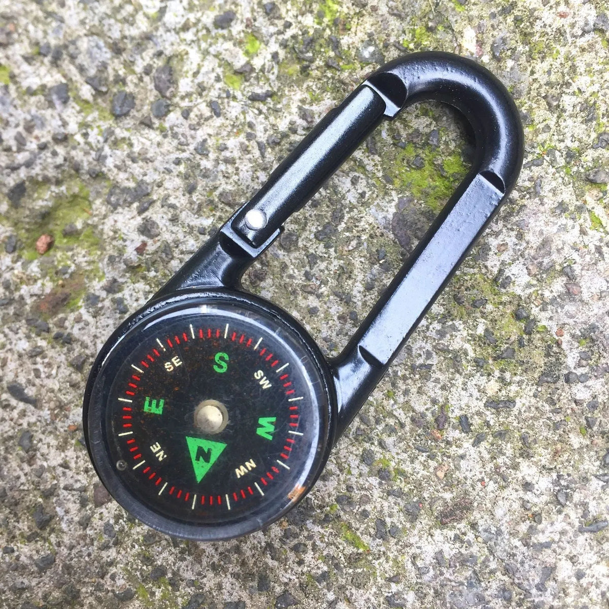 Black outdoor carabiner with a built-in circular compass and thermometer display on its side.