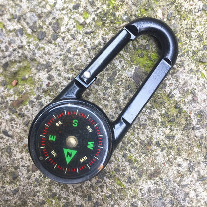 Black outdoor carabiner with a built-in circular compass and thermometer display on its side.