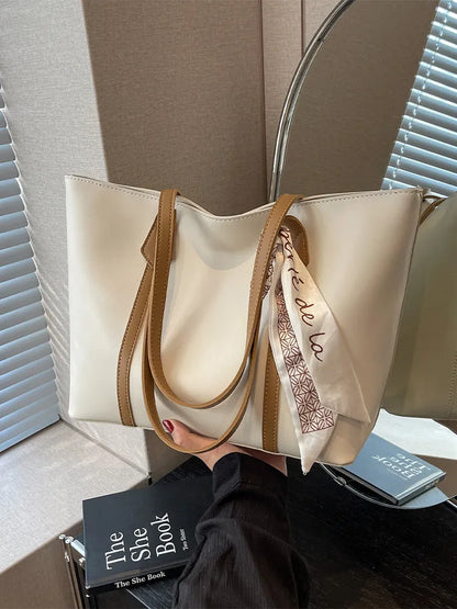 Soft large-capacity bucket tote bag with shoulder strap and zip pocket, shown in a neutral colour.