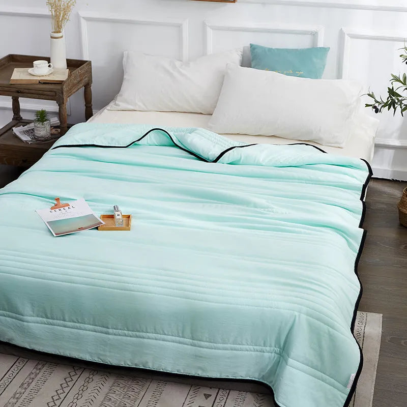 Lightweight plain coloured polyester summer quilt on a bed