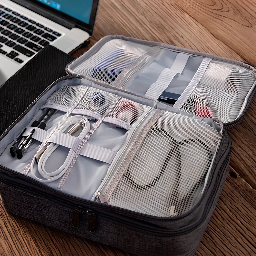 Gray waterproof electronics organiser bag open showing double-layer compartments with elastic loops and mesh pouches