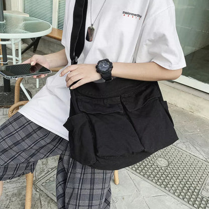 Canvas messenger bag in black, white, green, and brown with multiple pockets and adjustable strap