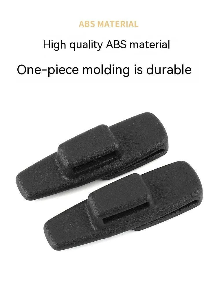 Two black ABS plastic car seat belt stopper clips on a clear OPP bag.