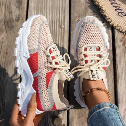 Women's Flyknit mesh lace-up sneakers in a grey colourway on a white background