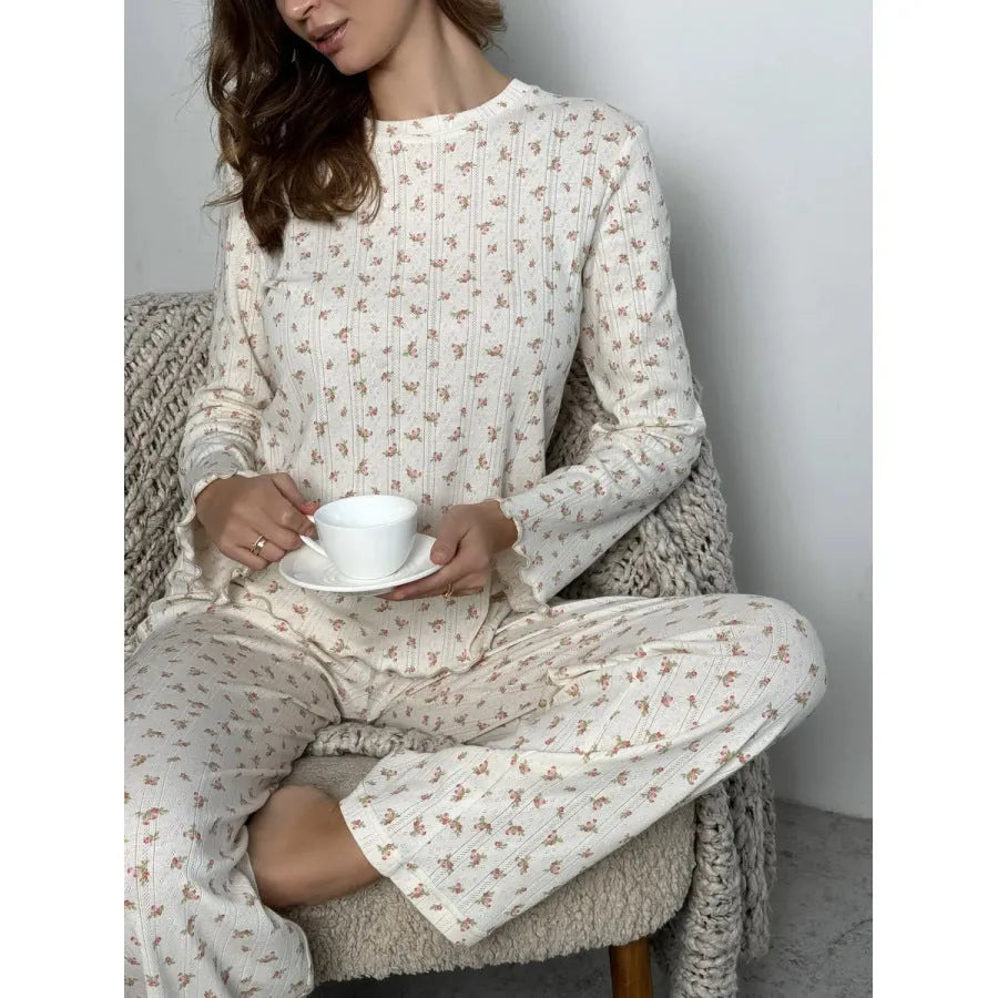 White floral print women's loungewear set with bell sleeve top and wide-leg trousers laid flat.