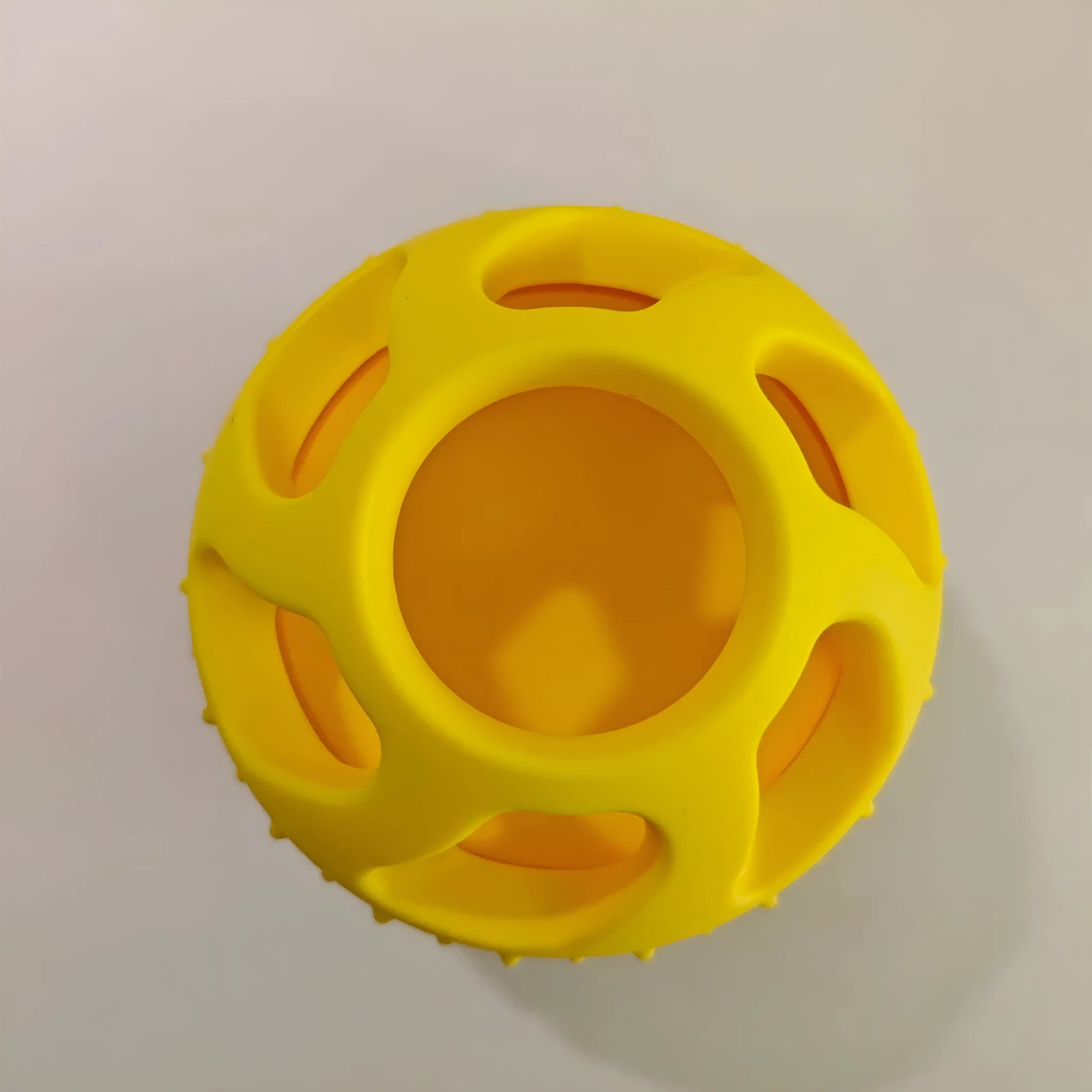 Yellow silicone pet slow feed ball with dental cleaning grooves and removable snack mold accessory