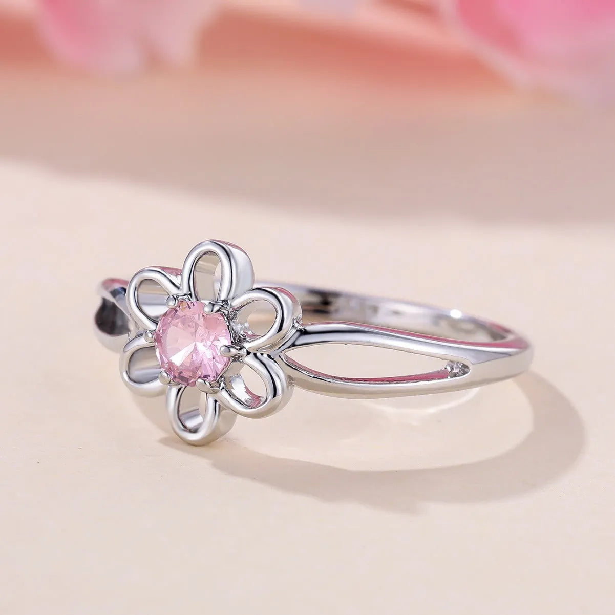 Women's hollow flower design fashion ring in electroplated copper with a platinum pink diamond finish.