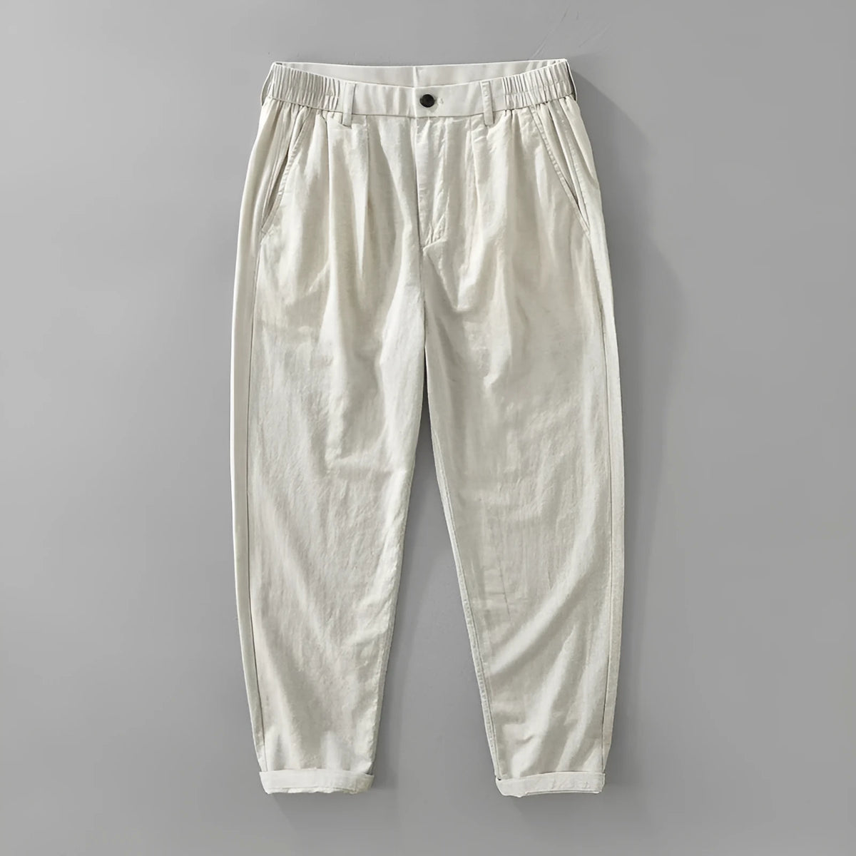 Man wearing loose beige straight-leg cotton linen trousers in a casual setting