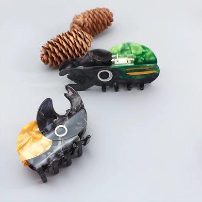 Handmade cartoon insect beetle grip hair clip or brooch in green, orange, or white designs.