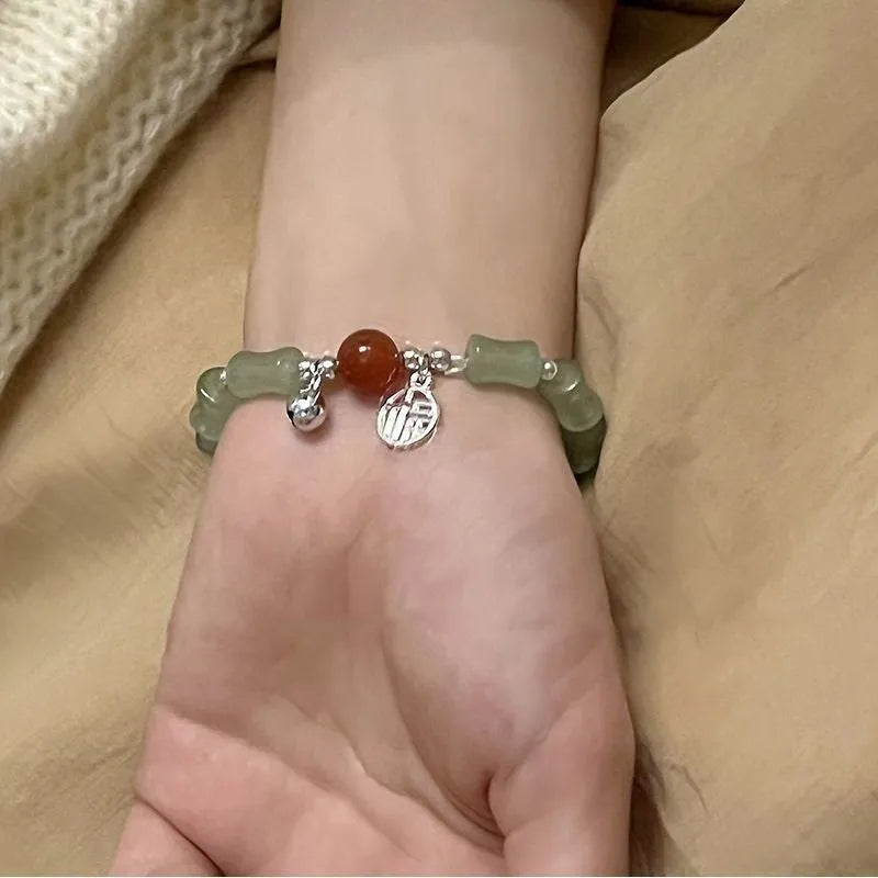 Chinese style glass bead bracelet with bamboo joint design on wrist.