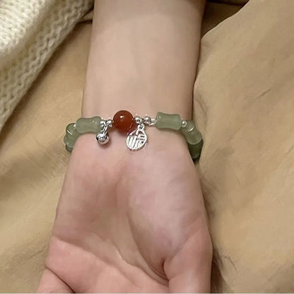 Chinese style glass bead bracelet with bamboo joint design on wrist.