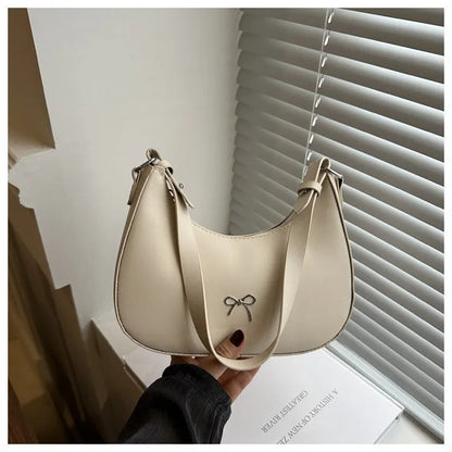Women's silver dumpling-shaped PU crossbody bag showing front sandwich pocket and single shoulder strap.